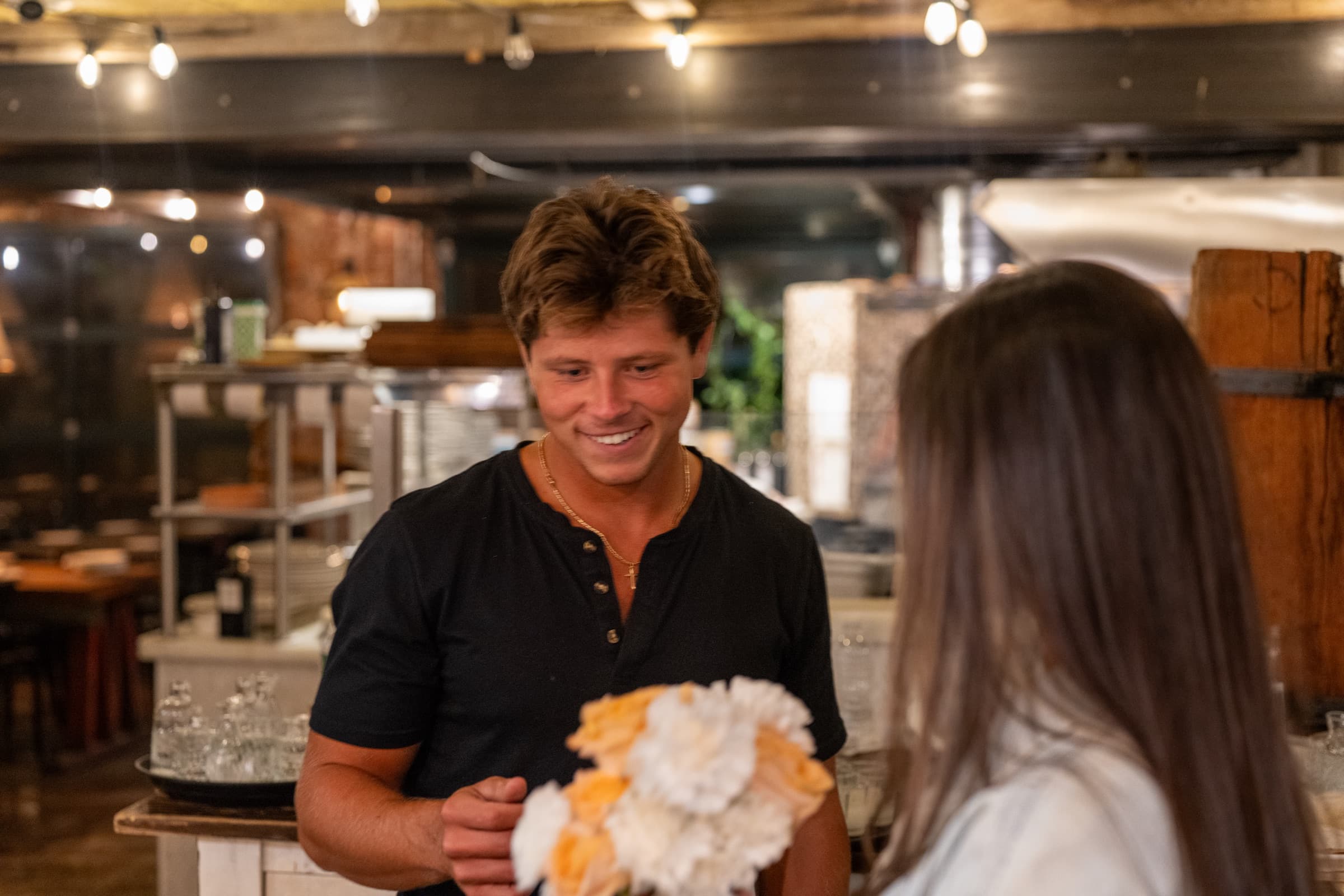 Flowers, handed over in a kitchen.